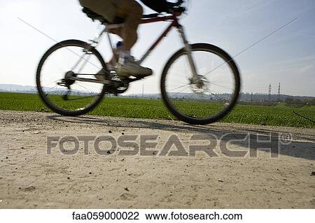 Stock Image - Riding bicycle, low section. Fotosearch