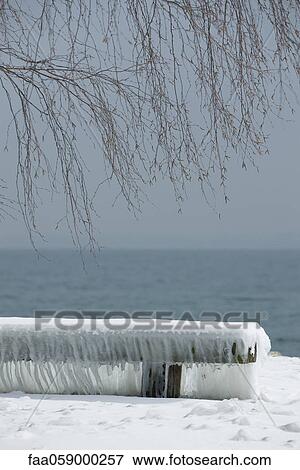 Snow-covered bench at water's edge View Large Photo Image Stock Photo - Snow-covered bench at water's edge. Fotosearch