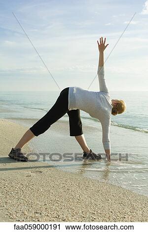Woman doing yoga at the beach View Large Photo Image Stock Image - Woman doing yoga at the beach. Fotosearch