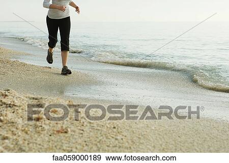 Woman jogging at the beach, low section View Large Photo Image Stock Photo - Woman jogging at the beach, low section. Fotosearch