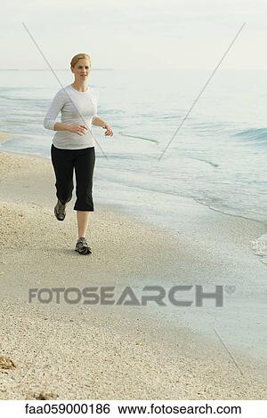 Woman running at the beach View Large Photo Image Stock Photograph - Woman running at the beach. Fotosearch