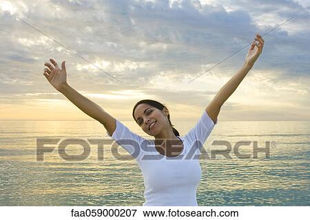 Woman stretching on the beach at sunset View Large Photo Image Stock Photo - Woman stretching on the beach at sunset. Fotosearch