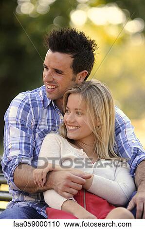 Young couple relaxing together outdoors, portrait View Large Photo Image Stock Image - Young couple relaxing together outdoors, portrait. Fotosearch