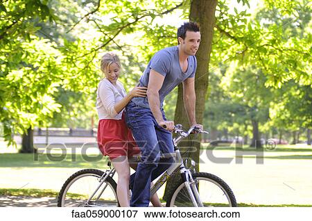 Young couple riding bicycle together View Large Photo Image Stock Photo - Young couple riding bicycle together. Fotosearch
