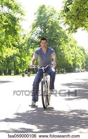 Young man riding bicycle View Large Photo Image Stock Photograph - Young man riding bicycle. Fotosearch