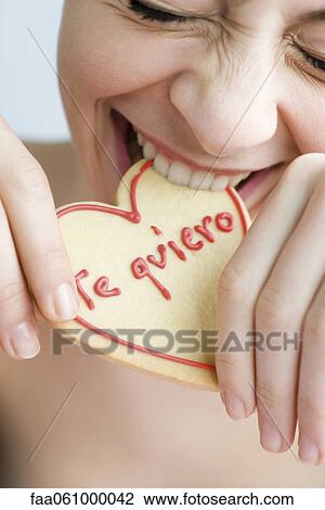 Biting into heart-shaped cookie View Large Photo Image Stock Image - Biting into heart-shaped cookie. Fotosearch