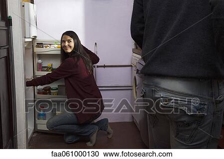 Couple in kitchen, woman getting food from refrigerator View Large Photo Image Stock Image - Couple in kitchen, woman getting food from refrigerator. Fotosearch