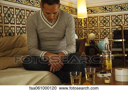 Depressed man sitting with alcohol on table View Large Photo Image Stock Image - Depressed man sitting with alcohol on table. Fotosearch