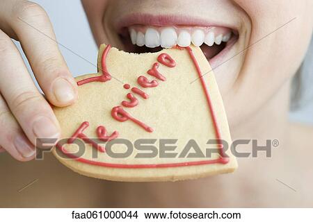 Eating heart-shaped cookie View Large Photo Image Picture - Eating heart-shaped cookie. Fotosearch