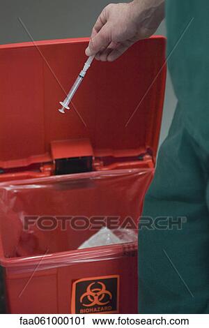 Healthcare professional placing used syringe in hazardous waste receptacle View Large Photo Image Stock Image - Healthcare professional placing used syringe in hazardous waste receptacle. Fotosearch