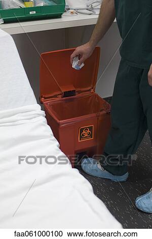 Healthcare professional putting trash in biohazard waste receptacle View Large Photo Image Stock Image - Healthcare professional putting trash in biohazard waste receptacle. Fotosearch
