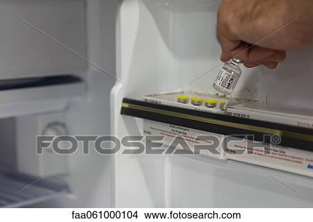 Healthcare professional removing medication vial from refrigerator View Large Photo Image Picture - Healthcare professional removing medication vial from refrigerator. Fotosearch