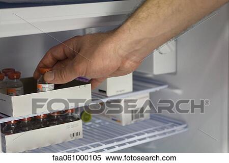 Healthcare professional removing medication vial from refrigerator View Large Photo Image Stock Photography - Healthcare professional removing medication vial from refrigerator. Fotosearch