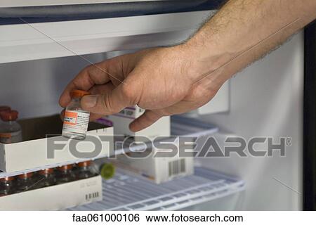 Healthcare professional removing vial of medication from refrigerator View Large Photo Image Stock Photograph - Healthcare professional removing vial of medication from refrigerator. Fotosearch