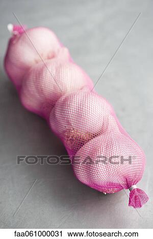 Mesh bag containing four garlic bulbs View Large Photo Image Stock Image - Mesh bag containing four garlic bulbs. Fotosearch