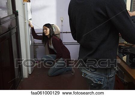 Woman with stomachache crouching before refrigerator View Large Photo Image Stock Photo - Woman with stomachache crouching before refrigerator. Fotosearch