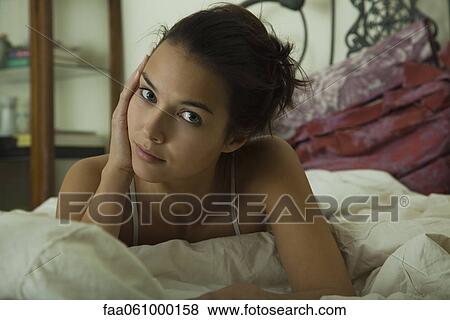 Young woman on bed, portrait View Large Photo Image Stock Photo - Young woman on bed, portrait. Fotosearch