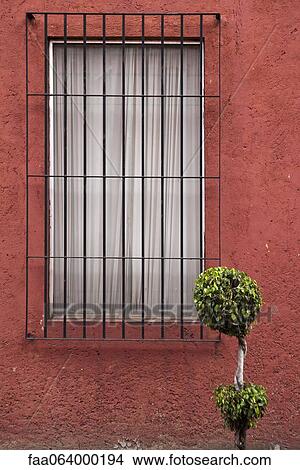 Picture - Barred window on stucco wall. Fotosearch