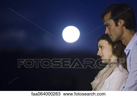 Couple embracing outdoors at night View Large Photo Image Stock Image - Couple embracing outdoors at night. Fotosearch