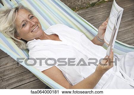 Mature woman relaxing in hammock, portrait View Large Photo Image Stock Image - Mature woman relaxing in hammock, portrait. Fotosearch