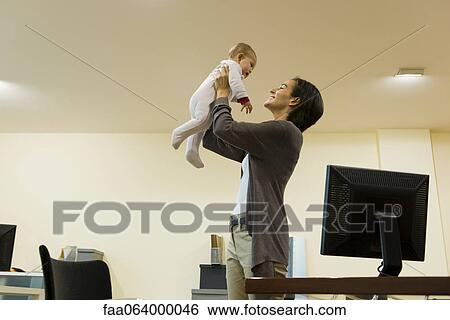Mother playing with baby in office View Large Photo Image Stock Photograph - Mother playing with baby in office. Fotosearch