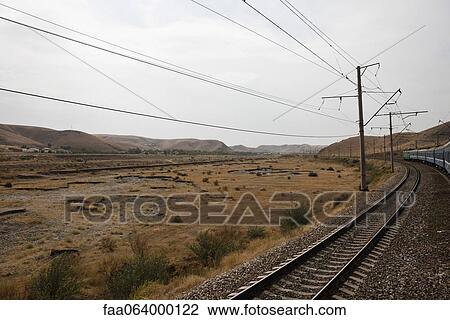Uzbekistan, Bukhara, Railway and power lines running through barren landscape View Large Photo Image Stock Image - Uzbekistan, Bukhara, Railway and power lines running through barren landscape. Fotosearch