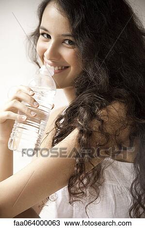 Stock Image - Young woman drinking water, portrait. Fotosearch