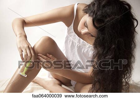 Young woman shaving legs View Large Photo Image Stock Photo - Young woman shaving legs. Fotosearch