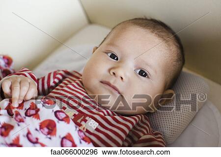 Stock Photograph - Baby lying down, portrait. Fotosearch