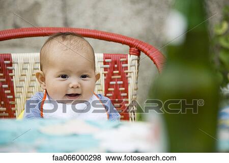 Baby sitting on a chair smiling View Large Photo Image Stock Photo - Baby sitting on a chair smiling. Fotosearch