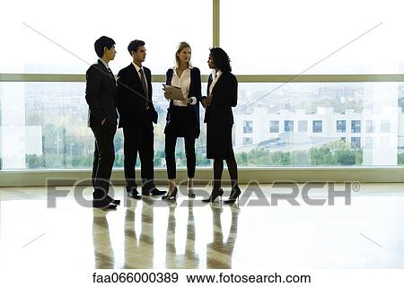 Business executives standing together talking View Large Photo Image Stock Photo - Business executives standing together talking. Fotosearch