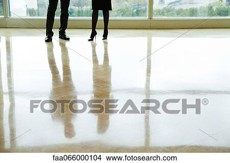 Businessman and businesswoman standing in lobby, low section View Large Photo Image Picture - Businessman and businesswoman standing in lobby, low section. Fotosearch