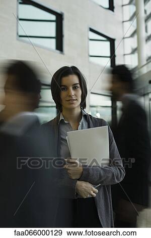 Businesswoman standing in busy lobby, portrait View Large Photo Image Stock Photo - Businesswoman standing in busy lobby, portrait. Fotosearch