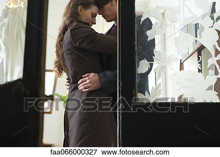 Couple embracing, viewed through open door View Large Photo Image Stock Photo - Couple embracing, viewed through open door. Fotosearch