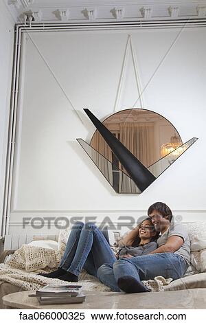 Couple relaxing together, looking at digital tablet View Large Photo Image Stock Photography - Couple relaxing together, looking at digital tablet. Fotosearch