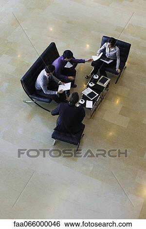 Stock Photograph - Executives having meeting, high angle view. Fotosearch