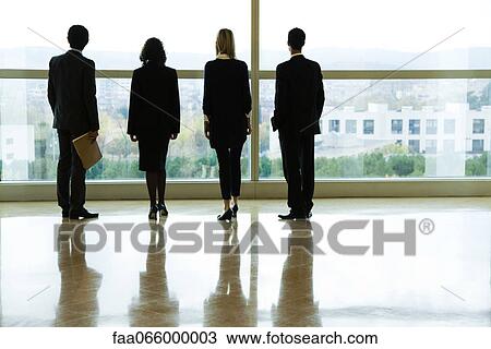 Executives standing side by side, looking through window, rear view View Large Photo Image Stock Image - Executives standing side by side, looking through window, rear view. Fotosearch