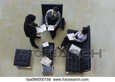 Stock Photo - Executives working together, overhead view. Fotosearch