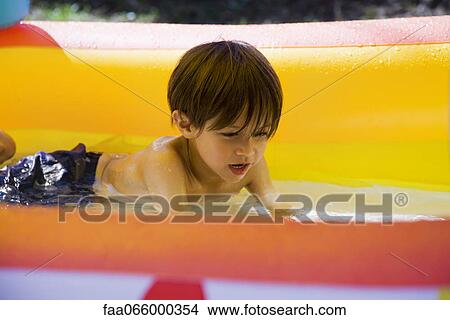 Little boy playing in wading pool View Large Photo Image Picture - Little boy playing in wading pool. Fotosearch