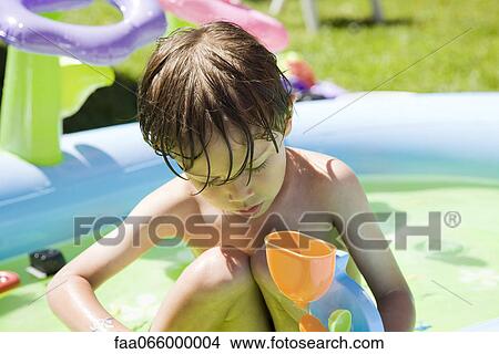 Little boy playing with toys in wading pool View Large Photo Image Picture - Little boy playing with toys in wading pool. Fotosearch