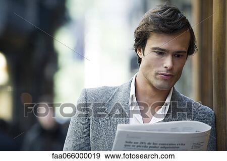 Man leaning against wall reading newspaper View Large Photo Image Stock Photo - Man leaning against wall reading newspaper. Fotosearch