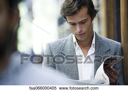 Man leaning against wall reading newspaper View Large Photo Image Stock Photography - Man leaning against wall reading newspaper. Fotosearch