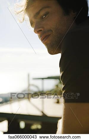 Man looking over shoulder at camera, portrait View Large Photo Image Stock Image - Man looking over shoulder at camera, portrait. Fotosearch