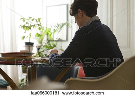 Man sitting at table reading View Large Photo Image Stock Image - Man sitting at table reading. Fotosearch