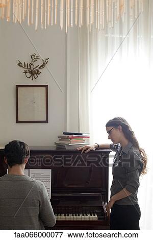 Stock Photo - Man taking piano lessons. Fotosearch