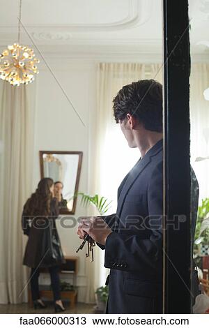 Man waiting impatiently in doorway while woman finishes applying make-up View Large Photo Image Stock Image - Man waiting impatiently in doorway while woman finishes applying make-up. Fotosearch