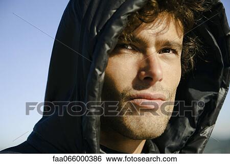 Stock Photograph - Man wearing hood, portrait. Fotosearch