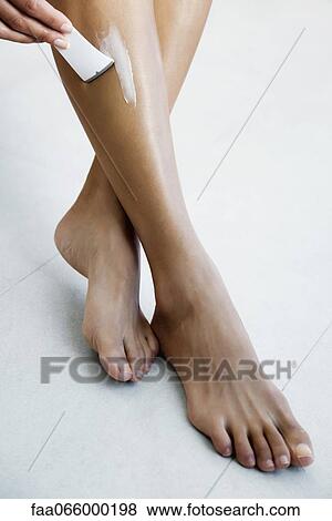 Woman applying hair removal cream to leg View Large Photo Image Stock Photo - Woman applying hair removal cream to leg. Fotosearch