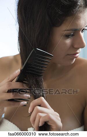 Woman combing hair after a shower View Large Photo Image Stock Image - Woman combing hair after a shower. Fotosearch