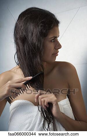 Woman combing her hair after a shower View Large Photo Image Picture - Woman combing her hair after a shower. Fotosearch